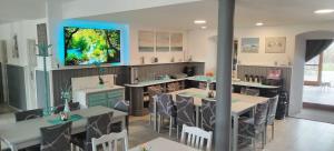 a restaurant with tables and chairs and a tv on the wall at Penzion Axiom in Frymburk