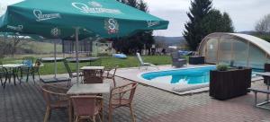 a patio with tables and chairs next to a pool at Penzion Axiom in Frymburk