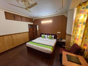 1 dormitorio con 1 cama y 1 mesa en una habitación en Woodstock Inn Manali en Manāli