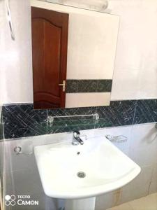 une salle de bain avec un lavabo blanc et un miroir dans l'établissement Superbe appartement cosy accès+ mer 5', à Dakar