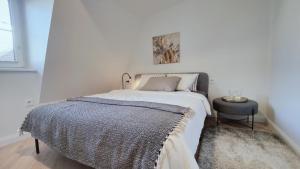 a white bedroom with a bed and a table at G-47 Near the Parliament - Self check in in Vilnius