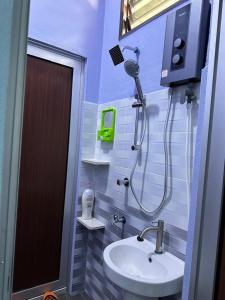 a bathroom with a shower and a sink at Homestay Haji Noor in Tanah Merah