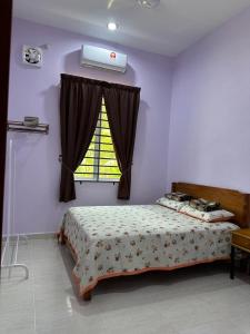 a bedroom with a bed and a window at Homestay Haji Noor in Tanah Merah