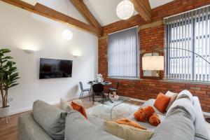 a living room with a couch and a brick wall at Cozy Downtown Loft in Bradford in Bradford