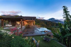 a house with a pool in front of a mountain at Munduk Mountain Estate in Munduk