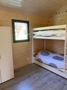 a bedroom with two bunk beds in a wooden cabin at Le chalet de Coheix in Mazaye
