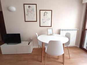 a white dining room with a white table and chairs at as maison in Terni