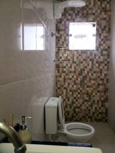 ein Badezimmer mit einem weißen WC und einem Waschbecken in der Unterkunft Casa com Spa. in Lagoa Santa