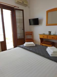 1 dormitorio con cama, escritorio y silla en ANATOLI ROOMS SERIFOS en Serifos