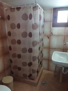 a bathroom with a shower curtain and a sink at ANATOLI ROOMS SERIFOS in Serifos Chora