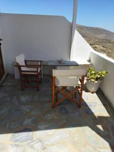 a table and a chair on a balcony with a view at ANATOLI ROOMS SERIFOS in Serifos Chora +4 photos