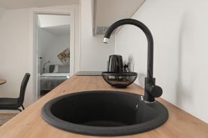 a black sink in a kitchen with a counter at G-47 Near the Parliament - Self check in in Vilnius