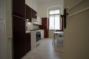 eine Küche mit einem schwarzen Kühlschrank und einem Tisch in der Unterkunft Manzoni 22 in La Spezia