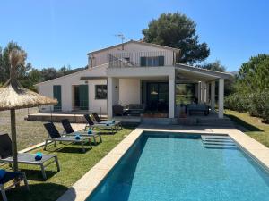 une villa avec piscine devant une maison dans l'établissement Villa Olivar - La Goleta Hotel de Mar & Villas, à Pollença