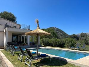 une piscine avec des chaises et un parasol à côté d'une maison dans l'établissement Villa Olivar - La Goleta Hotel de Mar & Villas, à Pollença