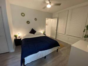 - une chambre avec un grand lit et une couverture bleue dans l'établissement Cozy Studio Bungalow Steps To Armature Works, à Tampa