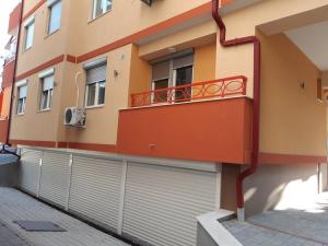 ein Gebäude mit zwei Garagentüren und einem Balkon in der Unterkunft Oficerski apartment in Bitola