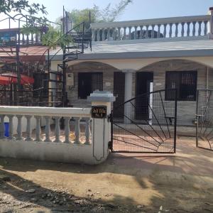 a house with a white fence and a gate at Juli villa in Daman