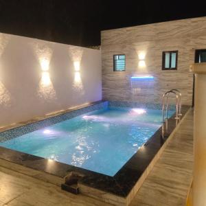 a swimming pool in a house at night at Juli villa in Daman