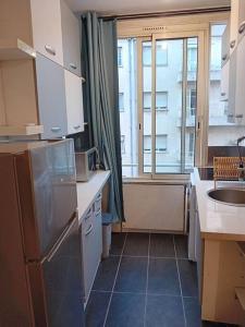 een keuken met een koelkast, een wastafel en een raam bij Lovely 3 rooms Nice riquier next to Port with AC! in Nice