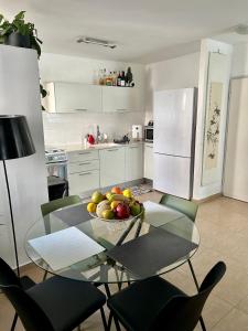 uma cozinha com uma mesa com uma taça de fruta em A private room in a modern apartment near the Belinson/Schneider hospital and the Red Line to Tel Aviv em Petaẖ Tiqwa