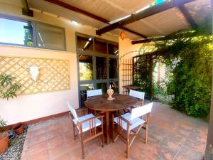 a wooden table and chairs on a patio at Casa vacanza comoda con vista in Bosa