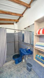 y baño con aseo azul y lavamanos. en Exclusiva casa de dos pisos con piscina privada, en Cali