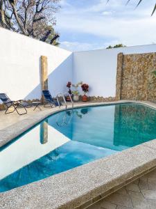 una piscina con sillas junto a una pared blanca en Exclusiva casa de dos pisos con piscina privada, en Cali