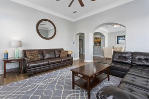 a living room with leather furniture and a table at Luxury Condo in Gulfport in Gulfport