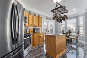 a kitchen with wooden cabinets and a stainless steel refrigerator at Luxury Condo in Gulfport in Gulfport