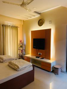 a bedroom with a bed and a tv on a wall at Vara in Varanasi