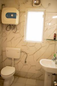 uma casa de banho com um WC, um lavatório e uma janela em Vara em Varanasi