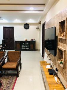 ein Wohnzimmer mit einem Flachbild-TV und einem Sofa in der Unterkunft Vara in Varanasi