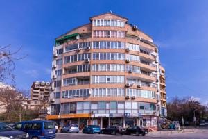 un grand bâtiment avec des voitures garées devant dans l'établissement The Cozy Hub, Varna, à Varna