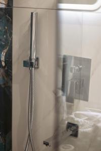 a shower in a bathroom with a glass door at Emily Apartments 3 in Chrysoupolis