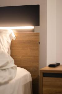 a bedroom with a bed with a wooden head board at Emily Apartments 3 in Chrysoupolis