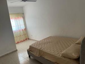 Schlafzimmer mit einem Bett und einem Fenster in der Unterkunft Samba Tako Plaza Home Suites in Sukuta