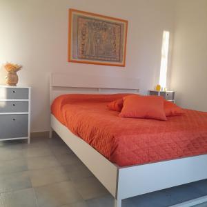 une chambre avec un lit avec une couverture orange dans l'établissement Villa Hakuna Matata, à Andria