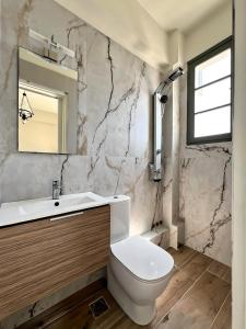 a bathroom with a white toilet and a sink at Kores Aegina in Agia Marina Aegina +30 photos
