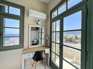 a room with windows and a desk and a mirror at Kores Aegina in Agia Marina Aegina