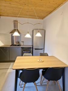 a kitchen with a wooden table and chairs at Cozychalet met prive Hot tub in Lanaken