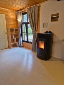 a living room with a wood stove in front of a window at Cozychalet met prive Hot tub in Lanaken