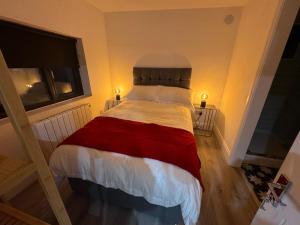 1 dormitorio con 1 cama con manta roja y blanca en Weston Studio en Lucan