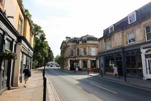 a street with buildings and people walking down the street at Suitely Stays Patio Apartment in Cheltenham