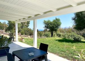 una mesa y sillas en un patio con vistas al océano en Sole Matto Rooms, en Olbia