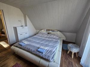 a small bedroom with a bed and a chair at Koliba Japa in Delnice