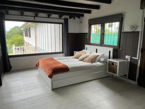 CarrenoにあるCasa Tomasのベッドと大きな窓のある寝室
