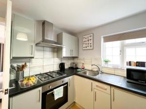 a kitchen with a sink and a stove top oven at Suitely Stays Berkeley Apartment 5 in Cheltenham