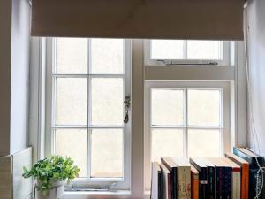 a book shelf with books in front of a window at Suitely Stays Berkeley Apartment 5 in Cheltenham