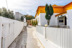 een wit hek voor een huis bij MADA HOUSE's II in Sesimbra